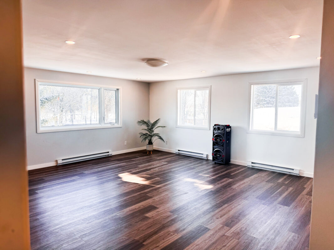 Salle lumineuse à louer à Trois-Rivières avec plancher de bois et grandes fenêtres, idéale pour ateliers, cours, yoga ou rencontres professionnelles.